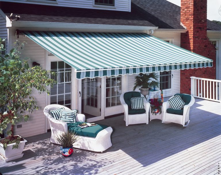 Eine gestreifte Markise erstreckt sich über eine gemütliche Terrasse mit Gartenmöbeln.